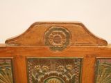 a wooden bed with a floral design on the headboard