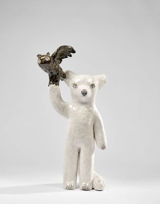 statue d'un ours polaire tenant un oiseau dans sa patte