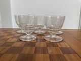 four empty wine glasses sitting on top of a wooden table