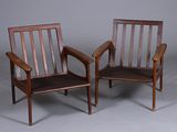 une paire de chaises en bois avec accoudoirs et pieds, sur fond gris