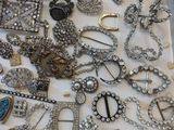 a box full of assorted brooches and jewelry