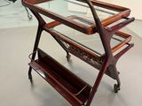 an image of a glass and wood trolley in a room