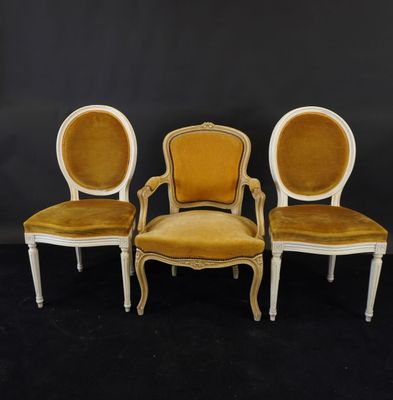 trois chaises recouvertes de velours jaune et dotées de pieds blancs