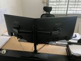 a computer monitor sitting on a desk in front of a window