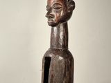 statue d'une femme portant un chapeau et tenant un bâton à la main
