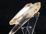 un cristal de quartz transparent posé sur un socle en acrylique transparent