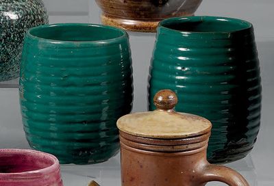de nombreuses tasses de différentes couleurs alignées les unes à côté des autres sur une table