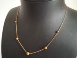 a black mannequin with a gold chain and beads on it