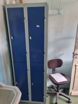 un grand casier bleu à côté d'une chaise dans une pièce