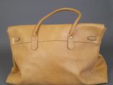 an ostrich leather tote bag on a grey background