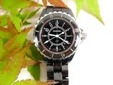a black watch sitting on top of a black bracelet