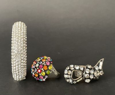 three pieces of jewelry are sitting on a black surface