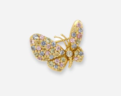 un gros plan sur une broche en forme de papillon ornée de pierres multicolores