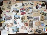 de nombreuses cartes postales anciennes posées sur une table, dont il y a beaucoup
