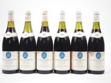 six bouteilles de vin alignées sur une surface blanche