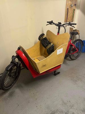un vélo rouge et jaune auquel est attelée une remorque