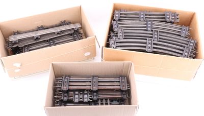 three cardboard boxes filled with different types of train tracks on a white surface