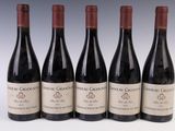 six bouteilles de vin sont alignées sur une surface blanche
