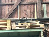 des palettes en bois empilées les unes sur les autres devant une grange