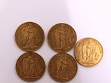 four gold coins with the image of a man and woman on them