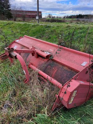un tracteur rouge assis dans l'herbe