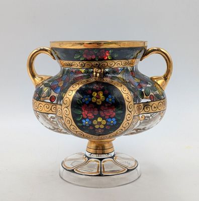 a vase with a floral design on it sitting on a stand