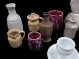 a lot of different vases and cups on the table