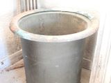 a large metal pot sitting on the floor next to a radiator