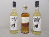 Trois bouteilles de whisky fumé sont alignées sur une table