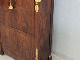 a wooden cabinet with a marble top and brass hardware