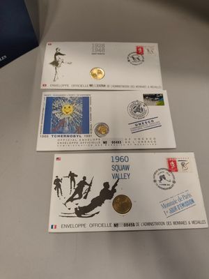 three different stamps and a coin are on a table