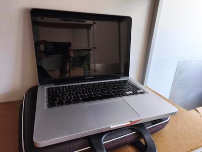 un ordinateur portable posé sur une valise, sur une table