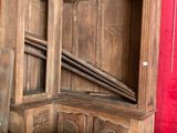une grande armoire en bois derrière laquelle se trouve un rideau rouge