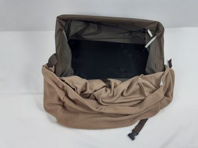 un sac ouvert contenant un ordinateur portable, posé sur une surface blanche
