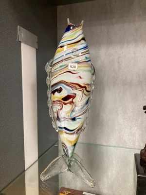 une sculpture en verre représentant un poisson, exposée dans une vitrine