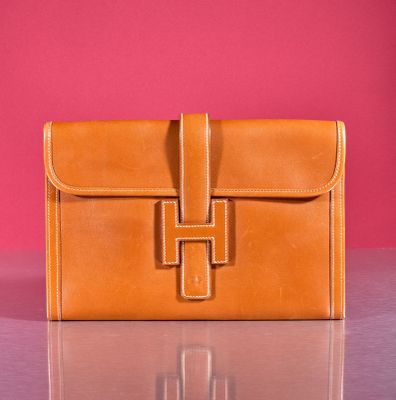 an image of a brown leather purse sitting on top of a table