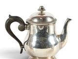 an old silver tea pot with a handle and a handle