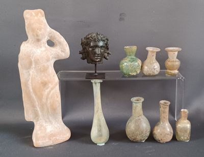 many vases and statues on a shelf with a gray background