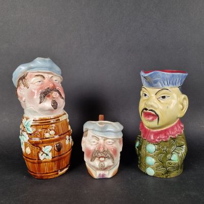 three ceramic figurines of men with hats and beards on them
