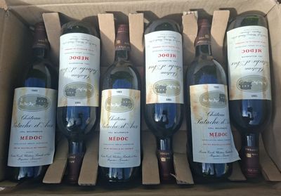 several bottles of wine are in a cardboard box on a table