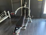 a gym room with a machine and a bench in it