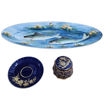 two plates and a bowl with fish on them