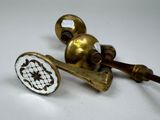 two antique brass door knobs on a white table