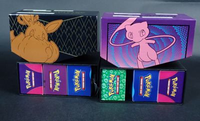 trois boîtes de cartes à jouer Pokémon posées sur une table