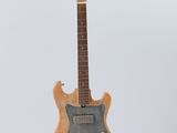 an electric guitar hanging from a string on a white wall