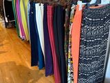 a lot of clothes hanging on a rack in a store