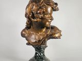 un buste en bronze représentant une femme avec une fleur dans les cheveux