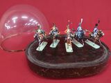des figurines représentant un groupe d'hommes à cheval sous un dôme en verre