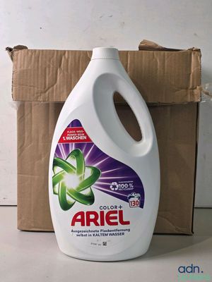 une photo d'un flacon de lessive Ariel à côté d'une boîte en carton