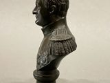 bronze bust of a man with a collared shirt on a pedestal